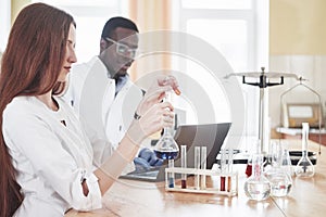 Laboratory laboratories conduct experiments in a chemical laboratory in transparent flasks. Output formulas