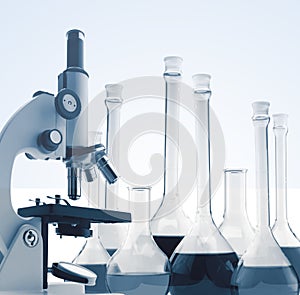 Laboratory metal microscope and test tubes with liquid toning