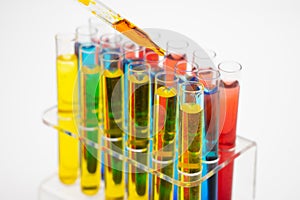 In the laboratory, scientists synthesized and analyzed the compound by dropping colored liquid in test tubes. White background