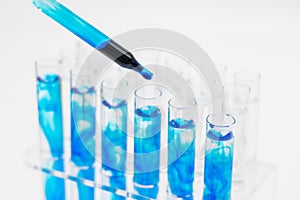 In the laboratory, scientists synthesized and analyzed the compound by dropping colored liquid in test tubes. White background photo