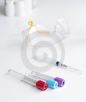 Laboratory table for a blood test. Test tube glasses syringe on a white table