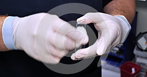 A laboratory technician degreases slides before performing a blood test. The doctor prepares slides for applying a blood