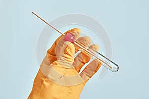 Laboratory technician holding sterile oral mouth swab in tube