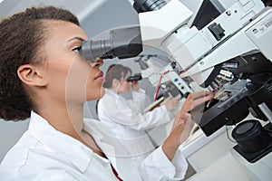 Laboratory technician looking into microscope eyepiece