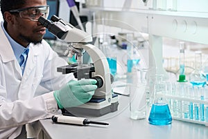 Laboratory Technician Looking at Samples Samples Using Microscope