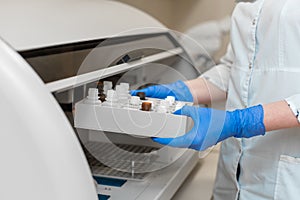 Laboratory technician test blood in automatic blood sample analyzer