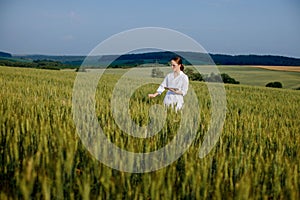 Laboratory-technician using digital tablet computer in a cultivated wheat field, application of modern technologies in