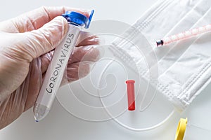 Aboratory vials with hand-written `coronavirus` concept, epidemiological threat of virus.  Notebook with the virus designation wri photo