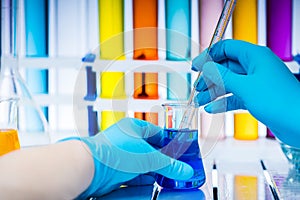 Laboratory worker analyzes chemical liquid in a flask.