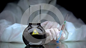 Laboratory worker holding syringe with poison, biochemical analyze, research