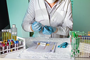 Laboratory worker manipulates a tube of blood