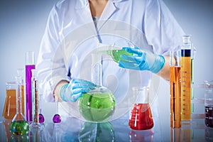 Laboratory worker mixes chemical liquid sample.