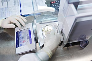 Laboratory worker in sterile rubber gloves, weighs the manufactured tablets on the control scales.