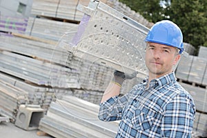 Laborer carrying aluminum frame