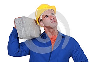 Laborer carrying cinderblock