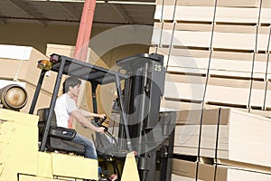 Laborer With Forklift Stacking Wood