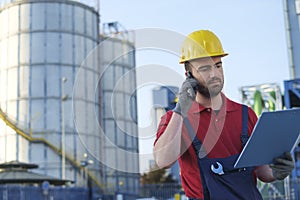 Laborer outside a factory working dressed with safety overalls