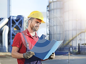 Laborer outside a factory working dressed with safety overalls e