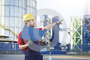 Laborer outside a factory working dressed with safety overalls e