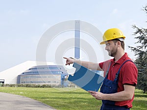 Laborer outside a factory working dressed with safety overalls equipment