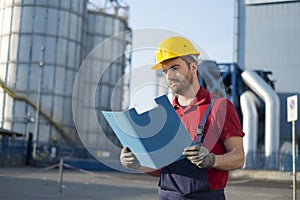 Laborer outside a factory working dressed with safety overalls equipment