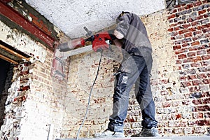 Laborer pierce a big round hole in a brick wall
