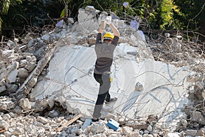 The laborer smashed pieces of the building with a hammer on demolish building. Earthquake, war, industry