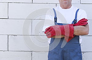 Laborer wearing protective clothing standing next to the white wall.Empty space for text