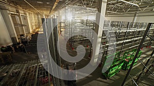 Laborers assemble metal racks in spacious plant warehouse