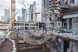 Laborers working on modern constraction site works in Dubai. Fast urban development consept