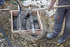 Laboriously shoveling, construction workers moving concrete/cement with shovels