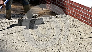 Labour builders construction workmen in the process of forming foundation concrete works with mixer truck