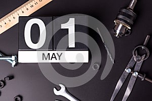 Labour day. May 1st. Day 1 of may month, calendar on black background with workers tools