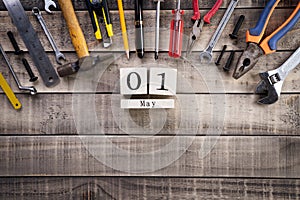 Labour Day, Wooden Block calendar with many handy tools on wooden background texture