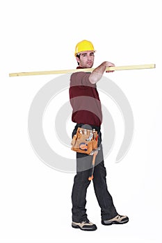 Labourer carrying a plank photo