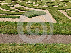 Labyrinth of green grass and sand in the garden.