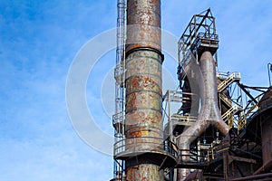 Labyrinth of rusted metal structures, old abandoned steel mill, ample blue sky copy space