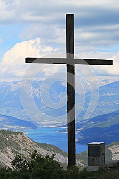 Cross above Lac de Serre-Poncon in the Hautes-Alpes, France photo