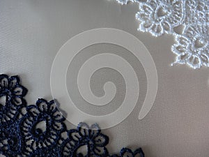 Lace in blue and white on a light satin background.