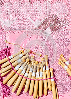 Lace bobbin in close-up with pink background photo