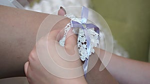 The lace garter is put on the bride`s leg