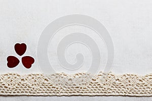 Lace ribbon hearts on white cloth.