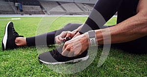 Lace, sneakers and man on stadium for running workout, training and performance on grass arena. Male athlete, runner and