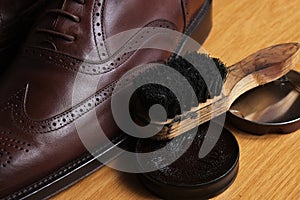 Laced brown leather classic Brogue shoes with polishing cream and brush