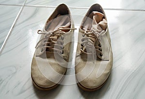 Laces of dirty women beige leather shoes with socks for outing in holidays