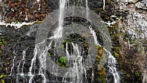 Lacey waterfall flows over rocks into a canyon