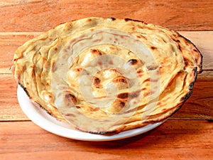 Lachha Paratha, a layered flat bread using wheat flour, popular dish in north India. isolated over a rustic wooden background,