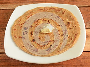 Lachha Paratha, a layered flat bread using wheat flour, popular dish in north India. isolated over a rustic wooden background,