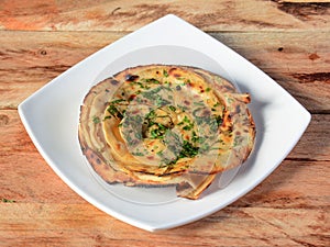 Lachha Paratha, a layered flat bread using wheat flour, popular dish in north India. isolated over a rustic wooden background,