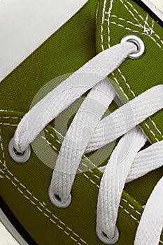 Lacing on a retro sneaker, close-up, on a blue wooden background